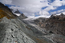 Lateral moraine deposit at edge of Findel Glacier. Glacier in retreat with braided stream below. Zermatt, Valais, Switzerland. September 2019.
