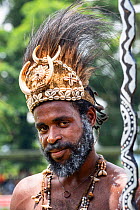 Papuan man in traditional headdress, portrait. At Sing-sing gathering where traditional cultures including dance and music are shared. Morobe Show, Lae, Papua New Guinea. 2019.