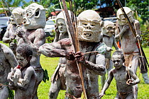 Mudmen, Papuan men in traditional clay masks, bodies painted with clay, boys also painted. At Sing-sing gathering where traditional cultures including dance and music are shared. Morobe Show, Lae, Pap...