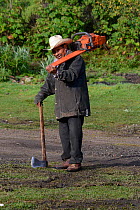 Logger - man carrying axe and a chainsaw, Sierra Chincua Sanctuary, Mexico.