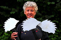 Susy Varndell leader of Dorset Mammal Group Hedgehog Project. Holding ghost hedgehog road signs used to raise awareness of hedgehog road deaths, and to encourage careful driving. Dorset, England, UK....