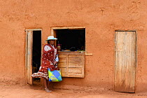 Woman standing outside shop. Central Madagascar. 2019.