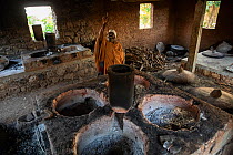 Monk next to ovens used for cooking enjeera. Mandaba Medhane Alhem Monastery, near Gorgora, Ethiopia. 2018.
