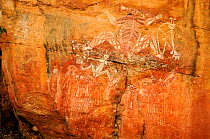 Aboriginal rock art depicting group of people and Namarrgon the lightning spirit. Lightning storms in October and November signal the beginning of the wet season. Nourlangie, Kakadu National Park, Nor...