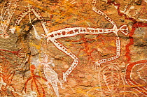 Aboriginal rock art depicting people and animal, possibly a crocodile. Kakadu National Park, Northern Territory, Australia.