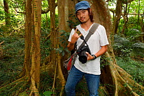 Photographer David Lin, in front of Bayan fig tree, (Ficus benjamina) one single individual tree, Bayan garden protected forest, Kenting National Park, Taiwan