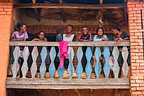 Local people relaxing on balcony, Hauts Plateaux, Central Madagascar. November 2018.