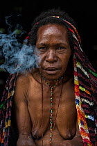 Dani tribe woman smoking, Budaya village, Suroba, Trikora Mountains, West Papua, Indonesia. March 2018.
