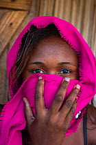 Local girl covering face with scarf, Palmarium, Eastern Madagascar. October 2018.