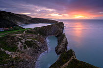 Stair Hole and Lulworth Cove at sunset. Folded limestone strata know as the Lulworth Crumple. Dorset, England, UK. November 2019.