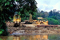 Deforestation of rainforest, logging machinery near river. Borneo.