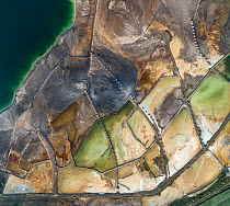 Aerial view of ash pond near Turek, Poland. Former open pit coal mine now used to store coal ash after burning in power plants. The ash is mixed with water and pumped through pipelines (fixed on sand...
