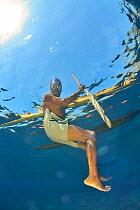 Local fisherman swimming near his outrigger canoe, Indonesia, Sea of Flores.