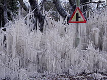 Road covered in icicles from splashed flood water, Hertfordshire, England, UK, February