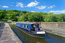 Barge navigating the Dundas Aqueduct which carries the Kennet and Avon Canal over the River Avon, near Limpley Stoke, Wiltshire / Somerset border, UK, August.
