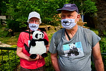 French tourists who love Giant pandas (Ailuropoda melanoleuca) with panda T-shirts, facemasks, caps and backpacks. Beauval ZooParc, Saint-Aignan, France. Model released. August 2021. Editorial use onl...