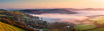Dorset from Somerset; layers of mist at dusk near Sandford Orcas from Corton Denham Beacon on a winter&#39;s afternoon, England, UK. January 2020.