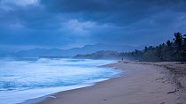 Jogger in distance on Playa Naranjos and the Caribbean Coast at dawn, Magdalena, Colombia