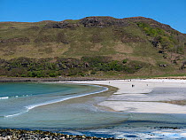 Calgary beach with people walking and Calgary Bay in the background, Isle of Mull, Scotland, UK. May.