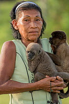 Woman holding Common woolly monkey (Lagothrix lagothricha) on the left Poepigg's woolly monkey (Lagothrix poepiggii) on the right. Both species from Maijuna Indigenous Community, different species on...