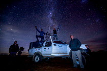 Camera crew with scientists from the Black-footed Cat Project, at night during filming of BBC series &#39;Big Cats&#39;, Karoo, South Africa. 2016.