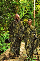 Photographers Helle and Uri Golman wearing camouflage ghillie suits when looking for mandrills, Lope National Park, Gabon. June 2016. Small repro only.