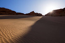 Sand dunes meeting rocky slopes, Sahara desert, Aydar, Southern Morocco, Africa. February, 2020.