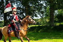 First Empire Military Re-enactment: Man dressed in uniform as a Lancier Plononais riding a French pony, Chateau du Plessis-Bourre, Maine-et-Loire, France. July 2021