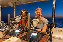 Nadine Boulotte, Southern Cross university PhD researcher and Katie Chartrand, Senior researcher at James Cook University examining tiny coral larvae under a microscope. Part of Coral IVF' team workin...