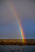 Rainbow over lava field, Santiago Island, Galapagos, South America. October, 2020.