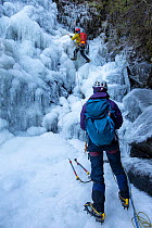 Ice climbers climbing frozen waterfall, Launchy Ghyll, Thirlmere, Lake District National Park, Cumbria, UK February, 2021.