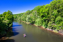 Two people in a Canadian canoe on the River Wye, Lower Lydbrook, Gloucestershire, UK. June, 2021.