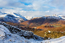 View of snow-covered hills, looking towards Bow Fell and the Langdale Pikes from Black Fell, Lake District National Park, Cumbria, UK. January, 2021.
