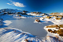 A frozen tarn on Tarn Crag above Easedale, Lake District National Park, Cumbria, UK. January, 2021.