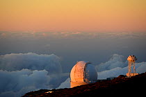Astronomical observator and, space radio telescope at sunset above the clouds, on the highest point of the island, Roque de los Muchachos, Caldera de Taburiente National Park, La Palma, Canary Islands...