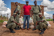 Rangers and community liaison (Piano Jantar Uache) responsible for distributing food in Micheu community, after Cyclone Idai. Outskirts of Gorongosa National Park, Mozambique. March 2019.