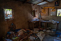 Office at Natiquiriqui school, strewn with books and papers that were destroyed during Cyclone Idai. Outside, people waiting for a food distribution. Outskirts of Gorongosa National Park, Mozambique....