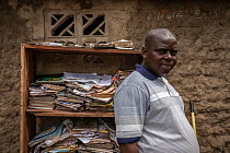 Fernando Chicanhe Luis (33), director of a school that experienced flooding to roof level after the cyclone, standing near bookshelf full of papers and books destroyed during Cyclone Idai. Outskirts o...