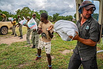 Pabloa Schapira, Operations Manager at African Parks' operation in Bazaruto National Park, working with staff and rangers to load food kits into an helicopter to bring to park's southern buf...