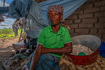 Rosa Domingo with her remaining food stores of dried maize and cassava root, after Cyclone Idai. Outskirts of Gorongosa National Park, Mozambique. April 2019.