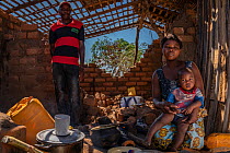 Domingo Jose Mita (30), Angelina Mauricio (28), and Abel Benjamin (14 months) in their collapsed home after Cyclone Idai. Outskirts of Gorongosa National Park, Mozambique. April 2019.