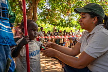 Nurse Berta Barros, checking height of child in Momba community in park's buffer zone during Medecins Sans Frontieres event. Outskirts of Gorongosa National Park, Mozambique. April 2019.