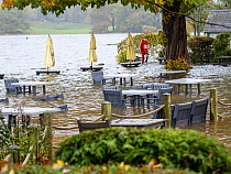 Floodwater submerging a pub beer garden after torrential rains caused Lake Windermere to reach very high levels, Ambleside, Lake District National Park, UK. October, 2021.