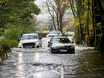 Abandoned cars on flooded road after torrential rains caused the River Rothay to break its banks, Ambleside, Lake District National Park, Cumbria, UK. October, 2021.