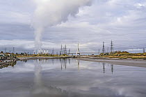Plume of steam rising from cooling towers at the Flint gas fired power station drifting over Flintshire Bridge, River Dee, North Wales, UK. November, 2021.