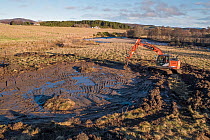An excavator working on wetland creation and wader scrapes, Ballinlaggan Farm, Cairngorms National Park, Scotland, UK. December, 2020.