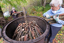 National Trust volunteers loading charcoal kiln with beech wood in preparation for burning, Killiecrankie, Perthshire, Scotland, UK. October.