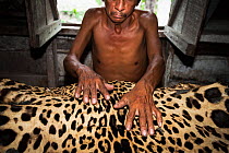 A hunter holding a Jaguar (Panthera onca) skin, Quintana Roo, Mexico.