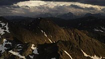 Aerial tracking shot of a mountain landscape with a storm brewing in the distance, Gsiesertal, South Tyrol, Italy, June.