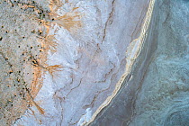 Aerial view showing the edge of Lake Eyre South: water (blue), salt pan edge (whites/pinks etc) and land  with water channels - the water and channels the result of recent uncommonly high local desert...